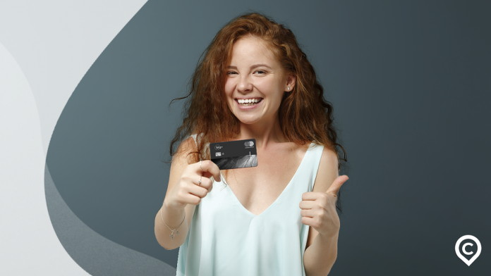 mulher com cartão btg+ black