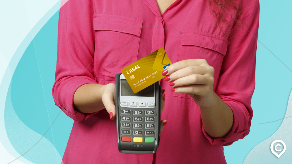 mulher segurando maquineta e cartão cabal